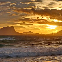 Sunset with surfer and the 332 meters high rock Penyal D'Ifac which is a landmark of Costa Blanca
